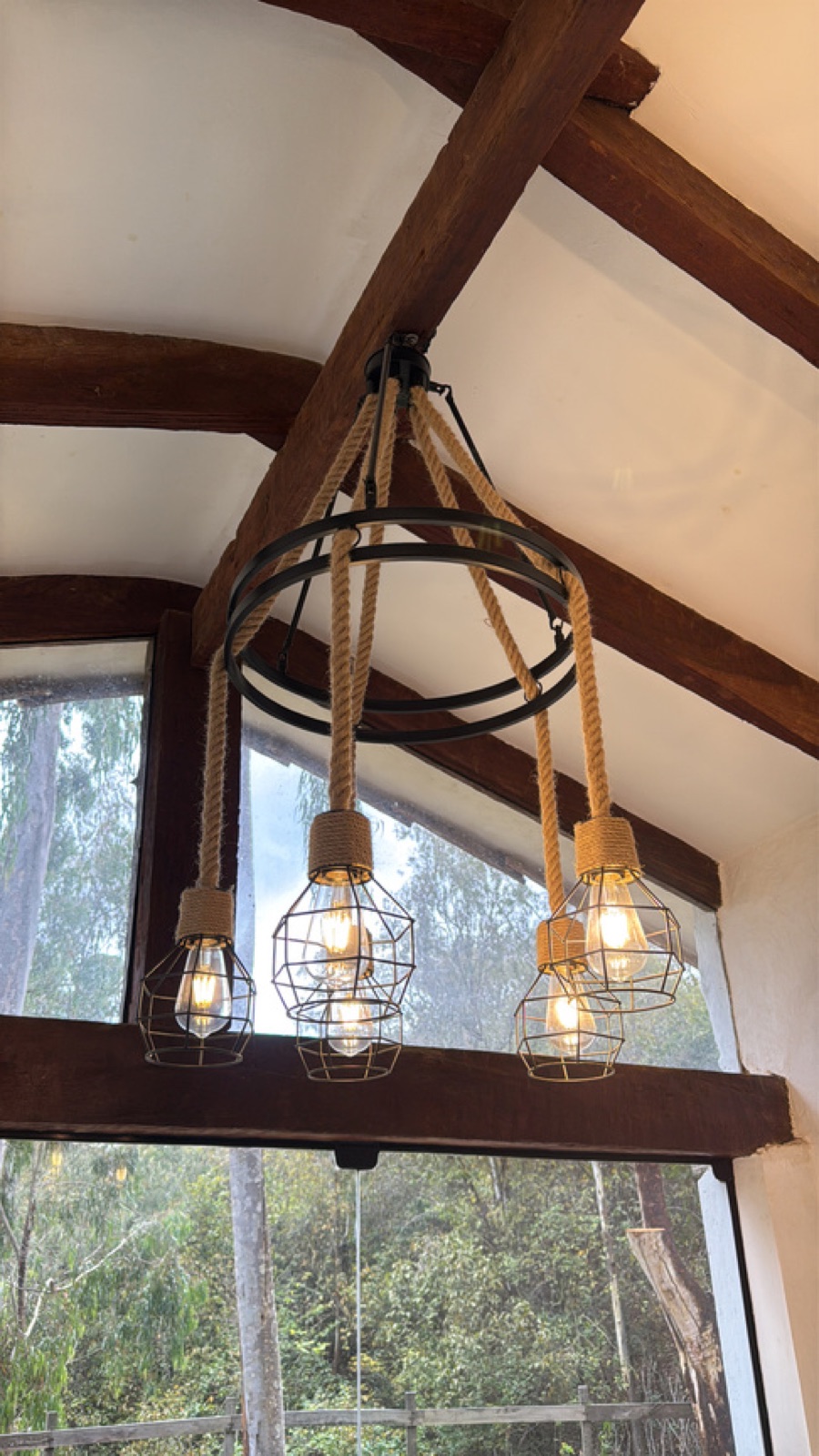 Detalle de iluminación con vigas de madera en la sala